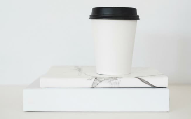 White coffee cup on two books